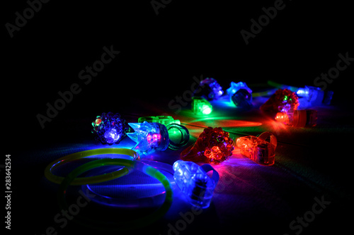 Grouping of neon glowing rings and sticks in a dark room