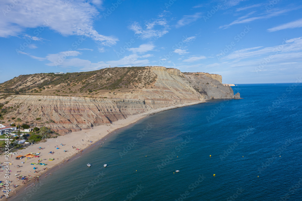 People on vacation on beautiful beach, Praia da Luz, Algarve, Portugal, summer aerial drone wide view