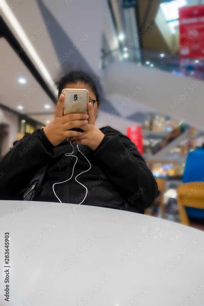 The girl sat on the chair with a happy mobile phone. The girl sat on the chair with a happy mobile phone.