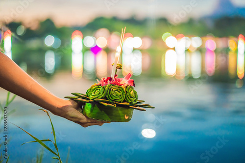 A female tourist holds the Loy Krathong in her hands and is about to launch it into the water. Loy Krathong festival, People buy flowers and candle to light and float on water to celebrate the Loy photo