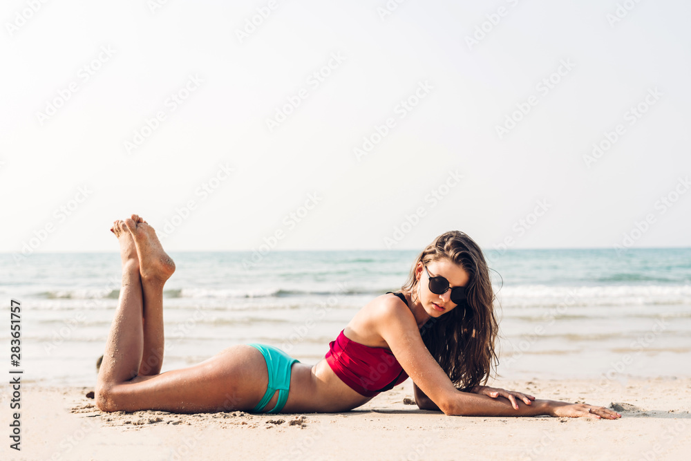 Portrait of smiling woman relaxation in red bikini on the tropical beach.Summer vacations