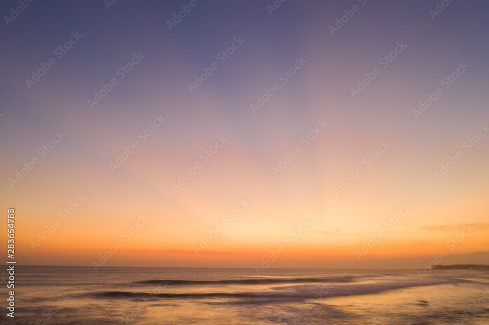 Fototapeta premium Aerial drone view of the sea over beautiful golden sunset sky background