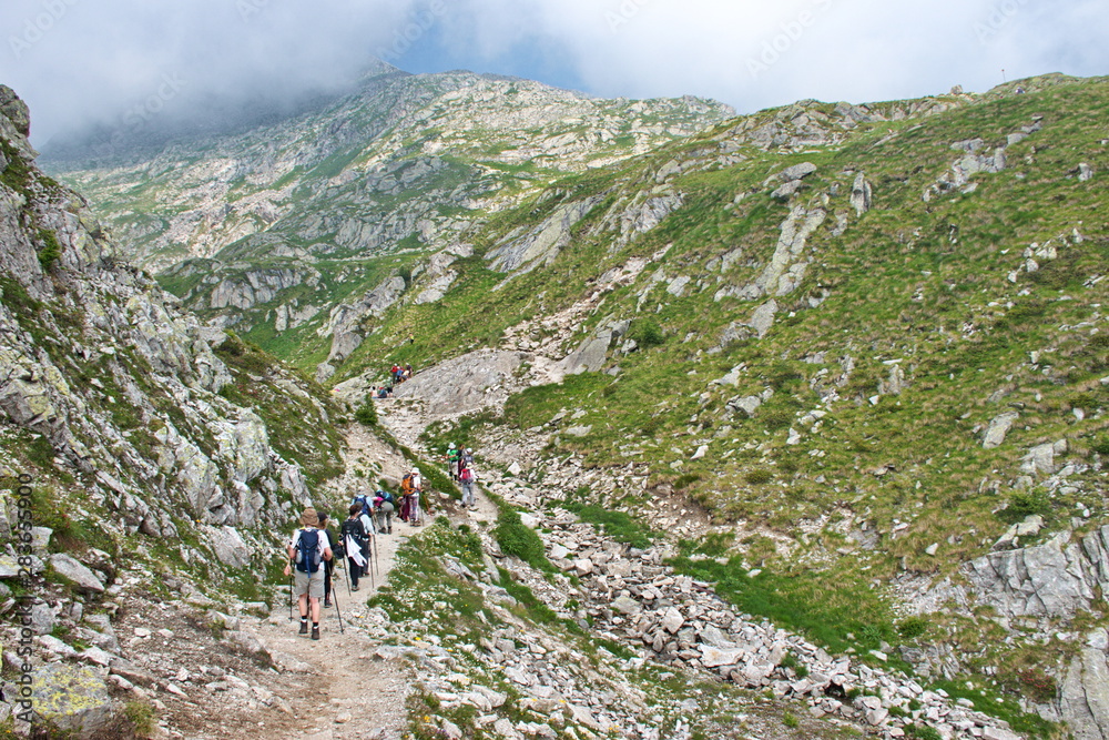 Rear view of mature and senior people hiking in Brenta Dolomites, Italy