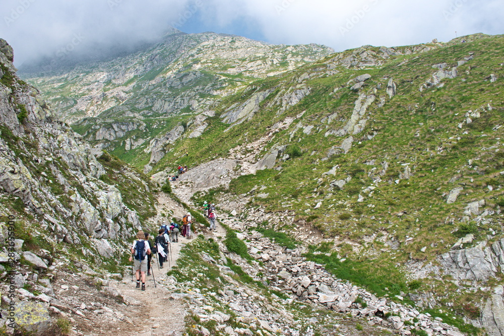 Obraz premium Rear view of mature and senior people hiking in Brenta Dolomites, Italy