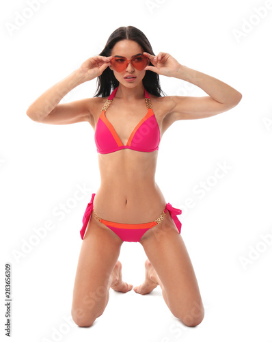 Beautiful young woman in stylish bikini with sunglasses on white background © New Africa