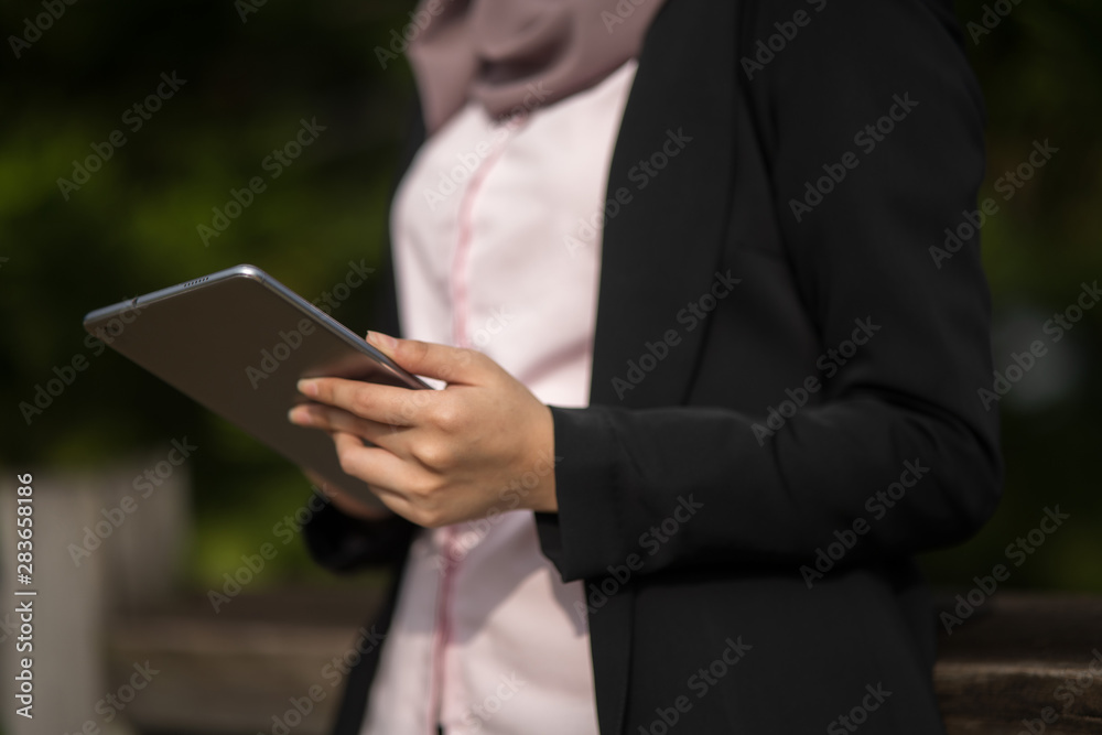 Close up of asian woman holding a tablet with green background