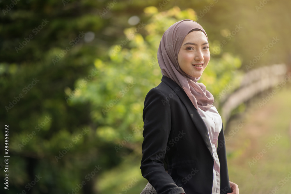 asian woman with a suit of blazer smiling with green background