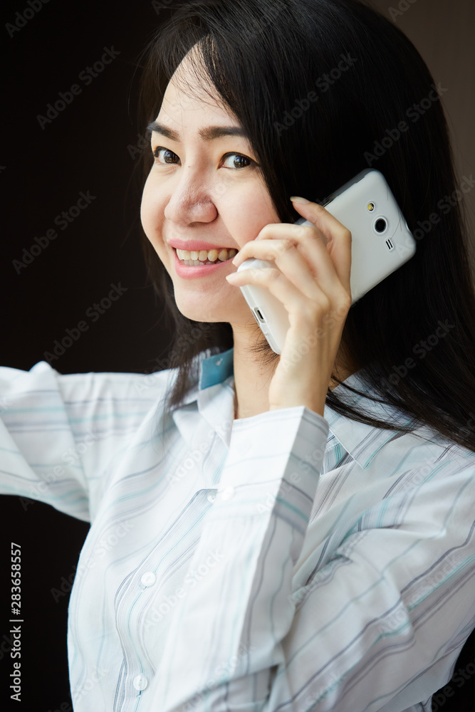 Asian busniness woman Is talking on a mobile phone Asian busniness woman Is talking on a mobile phone
