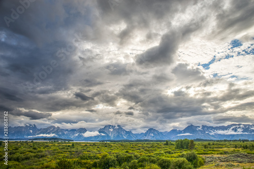 Canvas Print Dynamic Clouds Above Tetons with Green Grassy Fields