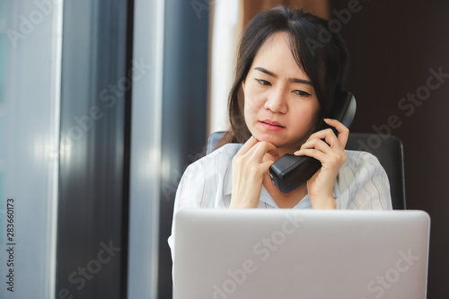 Happy asian business woman talking the phone at the working place. photo