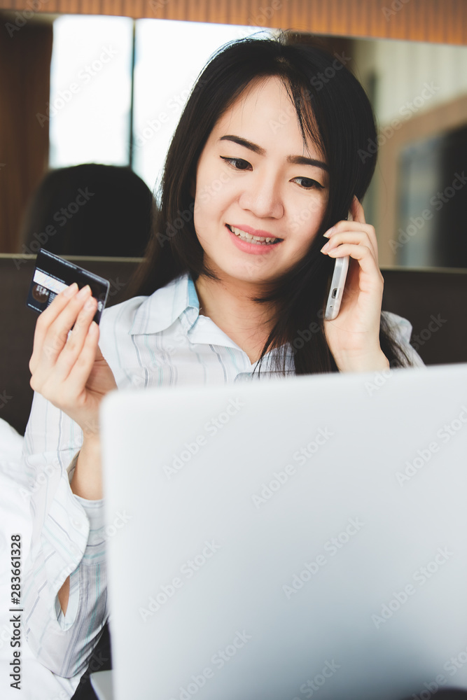 Portrait asian beautiful women are using credit cards and mobile phone to shopping online in the bedroom. Portrait asian beautiful women are using credit cards and mobile phone to shopping online in the bedroom.