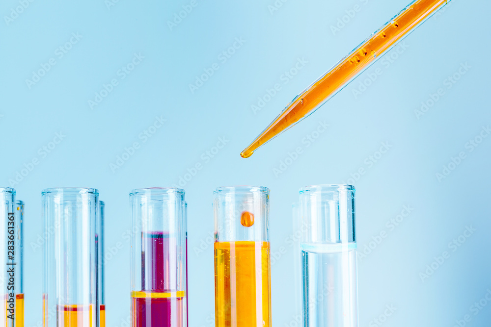 Laboratory test tubes with red and yellow liquids on light blue background  Stock Photo | Adobe Stock