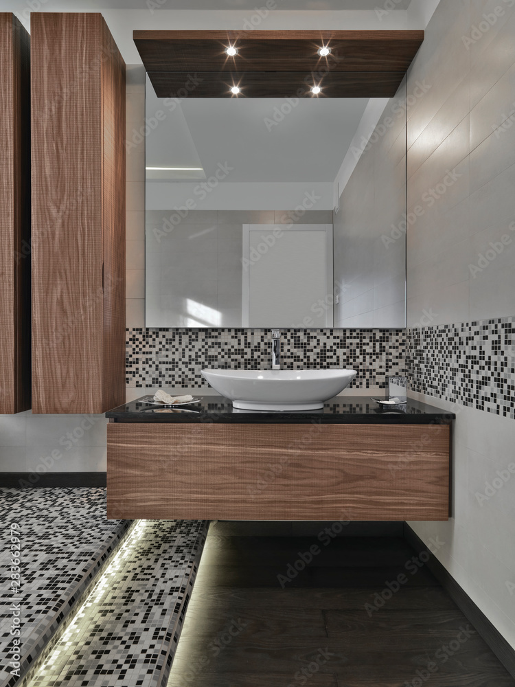 in the foreground the cabinets sink with conuter top washbasin and wood  floor in the modern bathroom Stock Photo | Adobe Stock