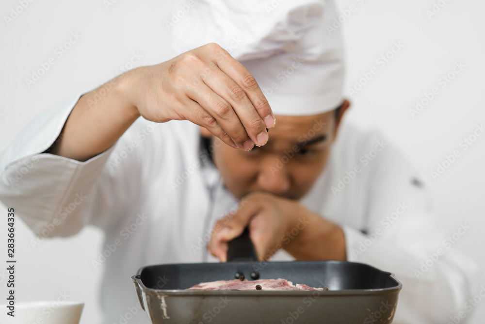 Chef spreading black peppers on meat for preparing food. Chef spreading black peppers on meat for preparing food.