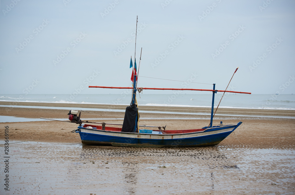 A blue fisherman boat on the beach