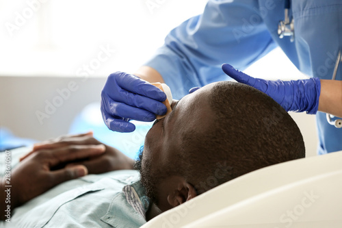 Plastic surgeon examining A...