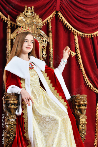 Portrait of beautiful princess with crown holding hand bell
