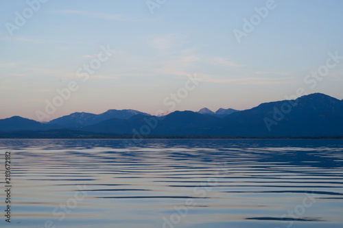 Blick auf die Alpen vom Boot auf dem Chiemsee w  hrend der blauen Stunde