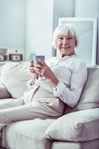 Beaming retired woman feeling relieved while spending day at home © zinkevych