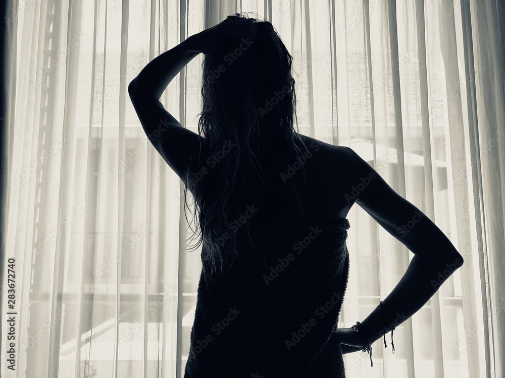 Woman with towel in front of a window and curtain. Woman with towel in front of a window and curtain.