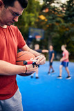 Man inflating basketball ball with a hand pump on the urban court.