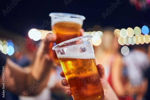 Photography Friends drinking beer at night with de-focused lights in the background