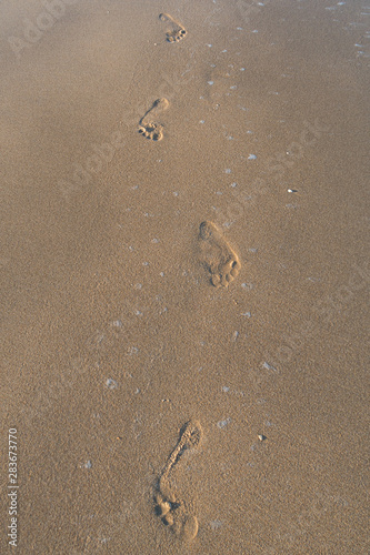human footprints in the fine sand at the beach