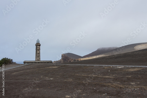 Obraz na płótnie View over Capelinhos volcano, lighthouse of Ponta dos Capelinhos on western coast on Faial island, Azores, Portugal. Last volcano eruption was in 1957. w salonie