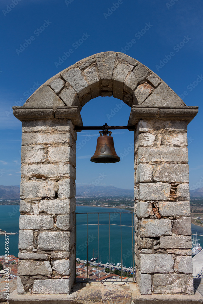 Bell on a stone arch overlooking city of Nafplio former capital of Greece, Peloponnese.