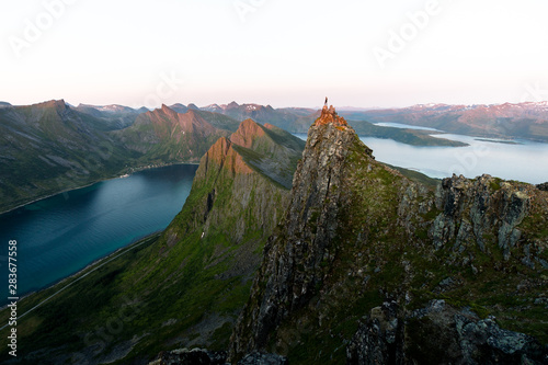 Norwegische Bergklippen mit Person während Sonnenuntergang auf Senja photo
