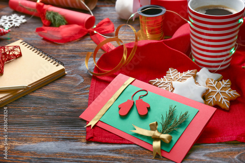 Handmade Christmas card with cookies and coffee on wooden table