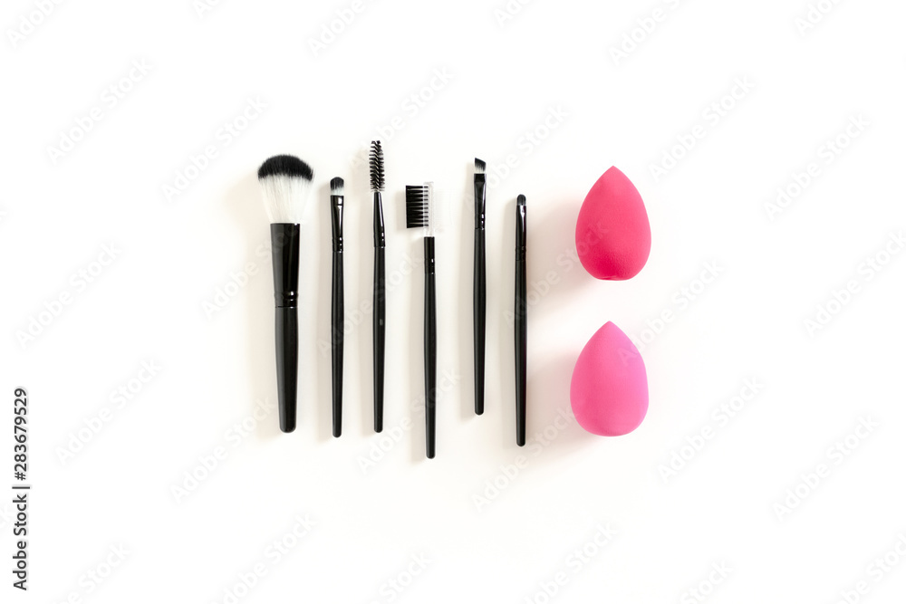 Cosmetic brushes and sponges on white background
