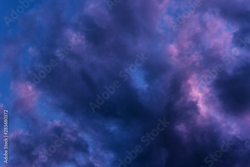 Blue hour sky clouds background. Beautiful landscape with clouds and purple sun on sky