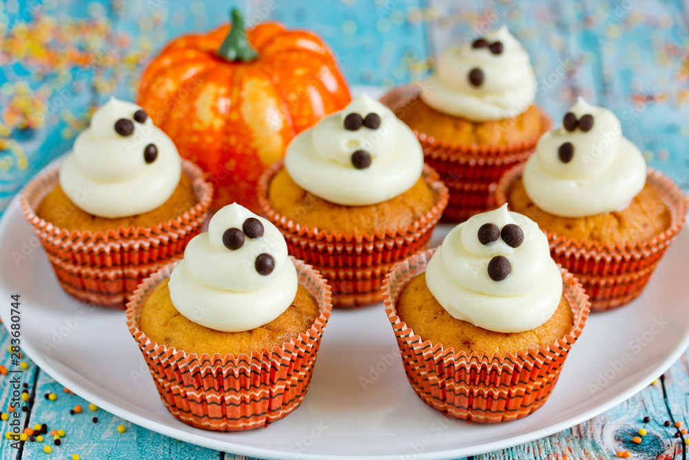 Halloween ghost cupcakes , homemade sweet pumpkin cakes with cream cheese frosting shaped funny ghosts for kid treats on Halloween party Halloween ghost cupcakes , homemade sweet pumpkin cakes with cream cheese frosting shaped funny ghosts for kid treats on Halloween party