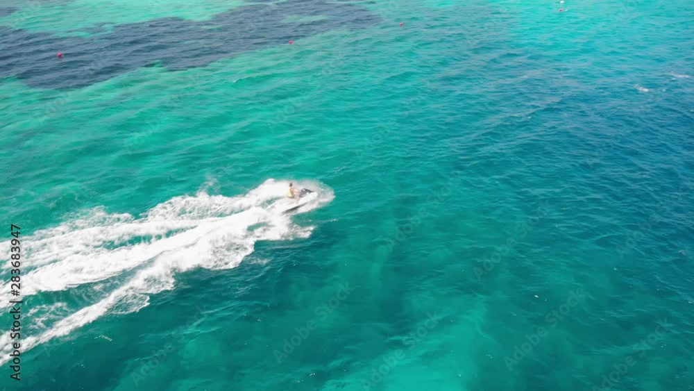 Aerial close up Drone shot of a man jet skiing in azure water. Ayia Napa, Cyprus Aerial close up Drone shot of a man jet skiing in azure water. Ayia Napa, Cyprus