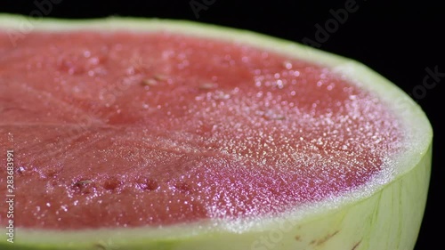 Watermelon gyrating on black background photo