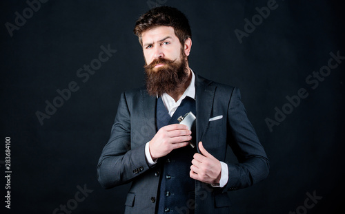Always with me. Flat metal bottle for alcohol. Man bearded hipster wear elegant suit hold metal flask for alcohol. Guy hide metal flask into pocket. Alcohol drink concept. Have alcohol drink with you