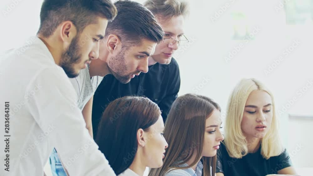 The working process. Casually dressed employees in the process of discussion of the project are bright and spacious office The working process. Casually dressed employees in the process of discussion of the project are bright and spacious office