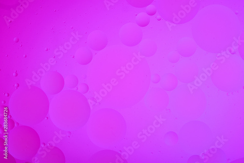 bright oily drops in water with colorful background, close-up 