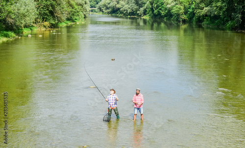 one mission. Big game fishing. male friendship. father and son fishing. adventures. two happy fisherman with fishing rod and net. recreation and leisure outdoor. hobby and sport activity. Trout bait