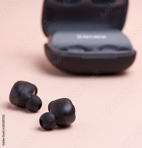 black wireless little earphones and a charging box