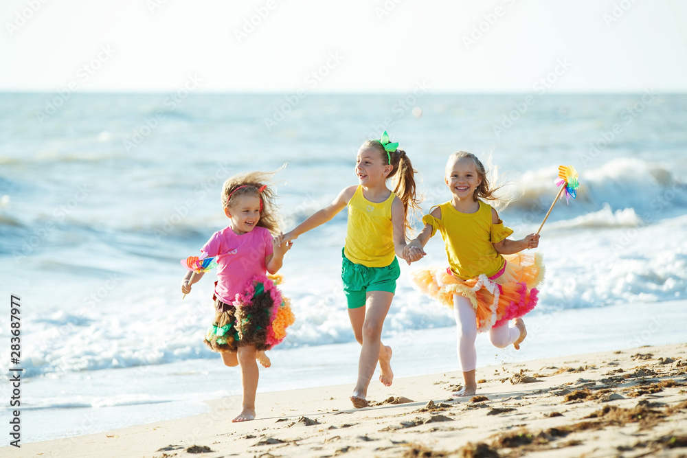 Children at sea. Little girls run on the sea on the waves. 