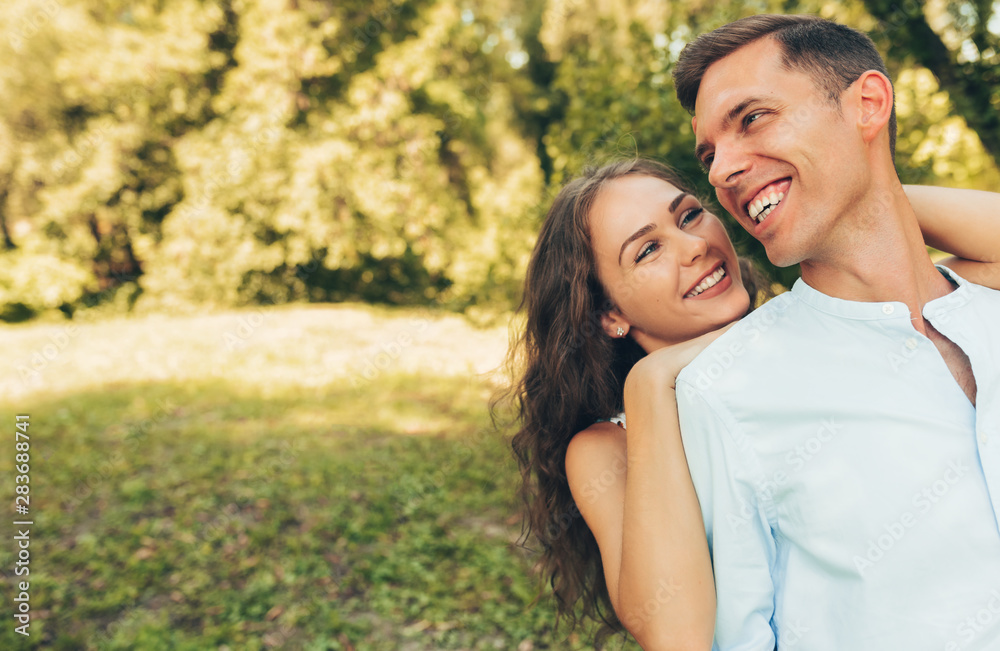 Outdoor portrait of romantic couple in love dating outdoors at the park on a sunny day. Happy couple in love embracing each other, looking with love having eyes full of happiness. Date day. Valentine Outdoor portrait of romantic couple in love dating outdoors at the park on a sunny day. Happy couple in love embracing each other, looking with love having eyes full of happiness. Date day. Valentine