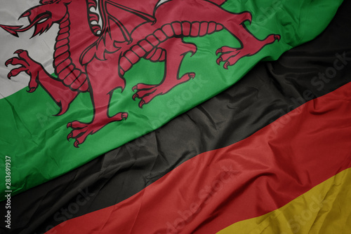 waving colorful flag of germany and national flag of wales.