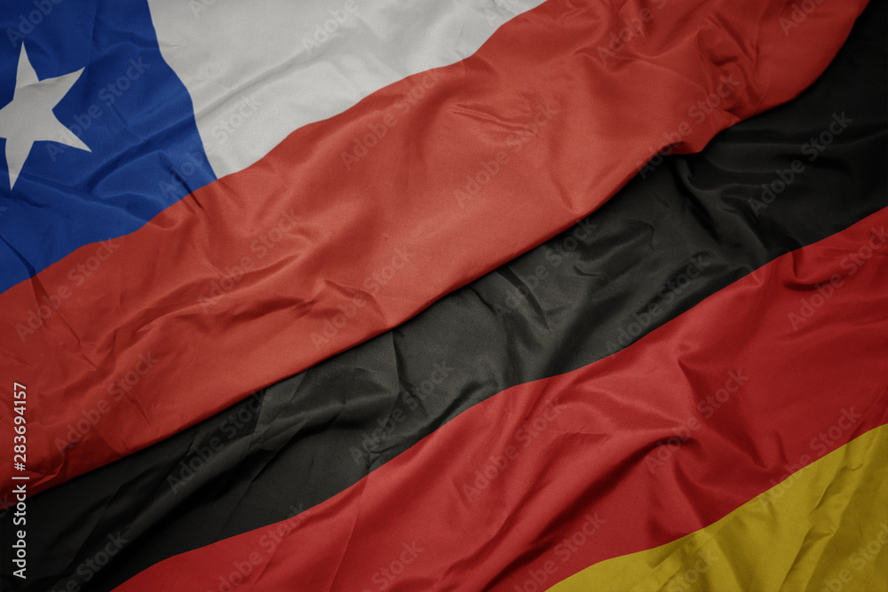 waving colorful flag of germany and national flag of chile. waving colorful flag of germany and national flag of chile.