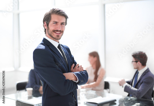 smiling young businessman standing in his office