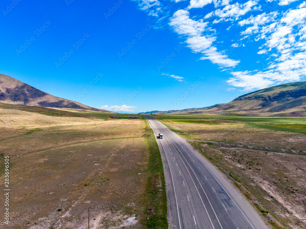 Fototapeta premium Aerial view of the road leading to Dogubayazit from Igdir. Plateau around Mount Ararat, mountains and hills. Eastern Turkey on the border with Armenia and Iran
