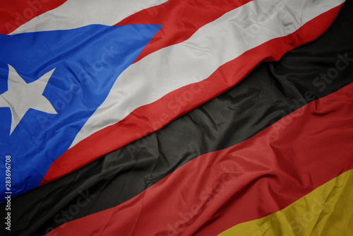 waving colorful flag of germany and national flag of puerto rico.