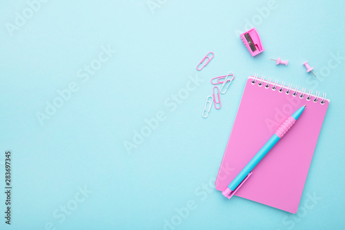 Pink school accessories on blue background. Back to school concept.