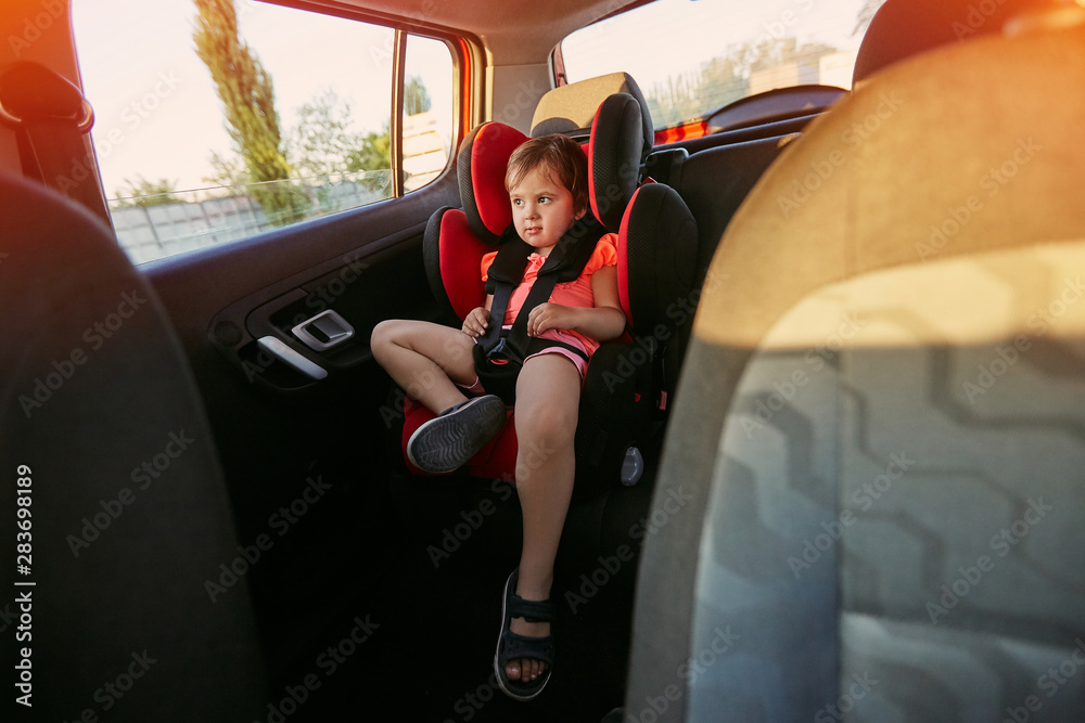 Fototapeta premium Adorable baby in safety car seat.